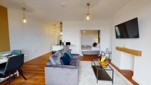 a living room with a couch and a tv at Studio Apartment with 65" Smart TV in Newport