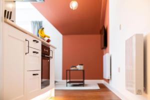 a kitchen with orange walls and a kitchen with a stove at Stylish Loft Apartment with View in Newport