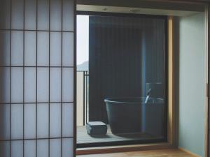 e bagno con vasca da bagno in una finestra. di SOKI ATAMI ad Atami