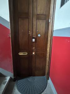 uma porta de madeira com um tapete em frente em Glasgow Center/West End Apartment em Glasgow