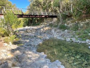 a bridge over a stream with a bridge over the water at U FARNIENTE in Patrimonio