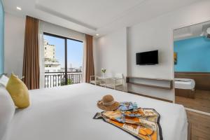 um quarto de hotel com uma cama grande e uma varanda em Beach Hotel by RAON - STAY 24H em Da Nang