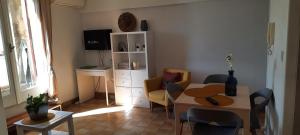 sala de estar con mesa, sillas y escritorio en appartement climatisé avec terrasse au coeur de Nyons, en Nyons
