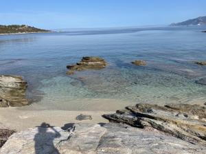 a view of a beach with rocks in the water at U FARNIENTE in Patrimonio