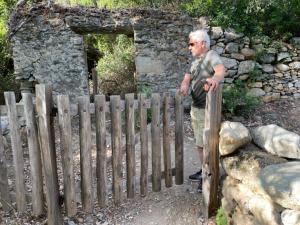 an older man standing next to a wooden fence at U FARNIENTE in Patrimonio