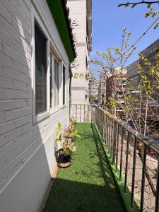 a balcony with grass and plants on the side of a house at Hongdae Luxury Private Single House with Big Open Balcony Perfect for a Family & Big Group 3BR, 5QB & 1SB, 2Toilet in Seoul