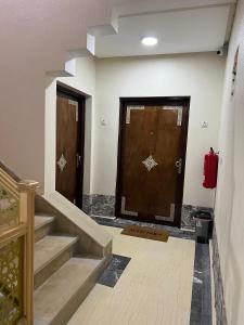 un pasillo con dos puertas marrones y escaleras en WANOLA APPART, en Chichaoua