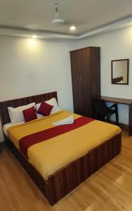 a bedroom with a large bed with a desk at Hotel New Cresent park in Coimbatore