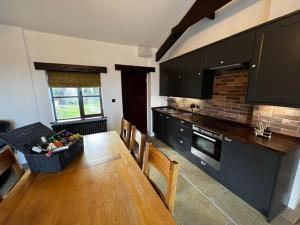 cocina con mesa de madera y comedor en Beautiful newly converted barn in St Hilary en Cowbridge