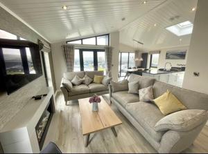 a living room with a couch and a table at *Luxury holiday home with hot tub close to beach* in Pembrokeshire