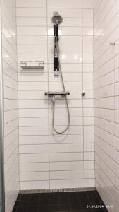 a bathroom with a shower with a phone on the wall at Nordgards Hagen in Lillehammer