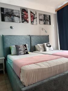 duas camas num quarto com fotografias na parede em Art Studios Benitses em Benitses
