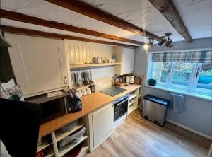 a kitchen with white cabinets and a counter top at Cosy cottage in peaceful location in Swansea