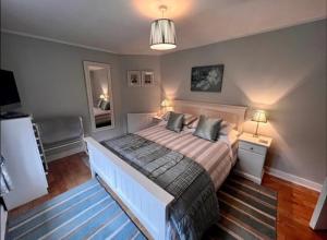 a bedroom with a large bed with two pillows at Cosy cottage in peaceful location in Swansea