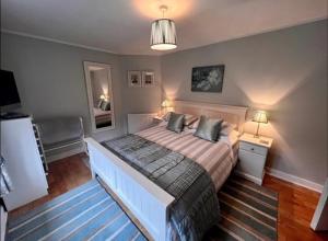 een slaapkamer met een groot bed met 2 kussens bij Cosy cottage in peaceful location in Swansea