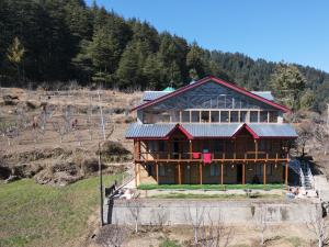 a large wooden house on a hill with trees at Ch'i SoulStone Retreat in Sainj