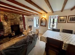 a living room with a table and a fireplace at Cosy cottage in peaceful location in Swansea