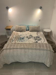 Un dormitorio con una cama grande con una manta. en La Vallée d'émeraude, en Plouër-sur-Rance
