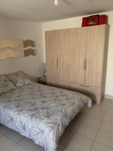 Schlafzimmer mit einem Bett und einem Holzschrank in der Unterkunft Studio martigues in Martigues