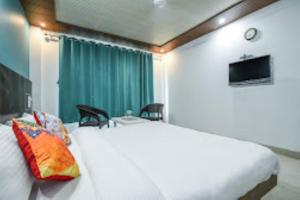 1 dormitorio con 1 cama blanca grande y cortina verde en Taarab View en Shogi