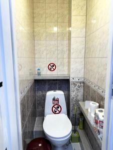 a bathroom with a toilet with two signs on it at Apartment in Chişinău