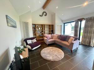 a living room with a couch and a table at Cosy barn with views in Wick Vale of Glamorgan in Wick