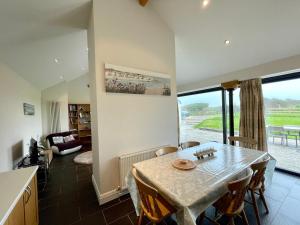 a dining room with a table and a living room at Cosy barn with views in Wick Vale of Glamorgan in Wick