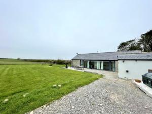 a house with a large green field next to it at Cosy barn with views in Wick Vale of Glamorgan in Wick