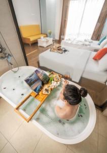 Eine Frau in einer Badewanne mit einer Mahlzeit darin. in der Unterkunft Beach Hotel by RAON - STAY 24H in Đà Nẵng