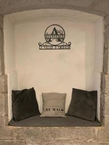 dos almohadas en un estante con un cartel en la pared en La Vallée d'émeraude, en Plouër-sur-Rance