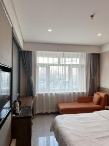 um quarto de hotel com uma cama, um sofá e uma janela em Biling Hotel em Fangshan