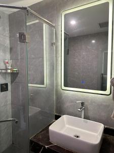 y baño con lavabo y ducha con espejo. en Biling Hotel en Fangshan