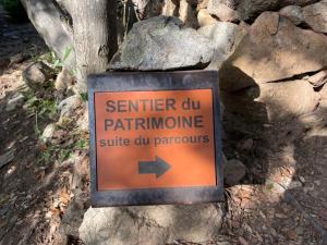 a sign that says squirrel cut patrine next to a rock at U FARNIENTE in Patrimonio