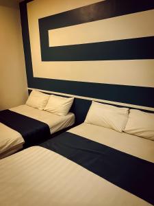 two beds sitting next to each other in a room at V Hotel Sri Gombak (Previously MyHome Hotel) in Batu Caves