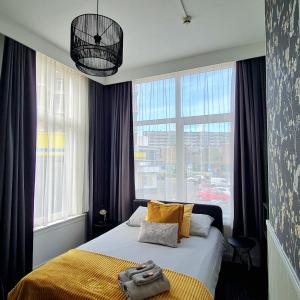 ein Schlafzimmer mit einem Bett und einem großen Fenster in der Unterkunft Hotel 't Witte Huys Scheveningen in Scheveningen