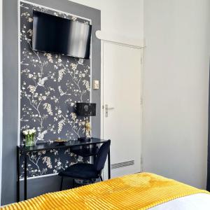 een slaapkamer met een bureau en een tv aan de muur bij Hotel 't Witte Huys Scheveningen in Scheveningen +30 foto's