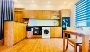 a kitchen with wooden cabinets and a washer and dryer at Sao Beach Bungalow in Phu Quoc