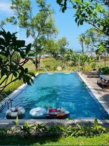 a swimming pool with chaise lounges and umbrellas at Sao Beach Bungalow in Phú Quốc