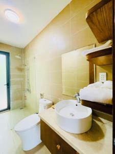 a bathroom with a white sink and a toilet at Sao Beach Bungalow in Phú Quốc