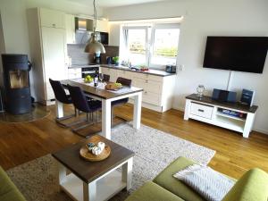 a living room with a table and a kitchen at Gode Wind Quartiere 1 in Dahme