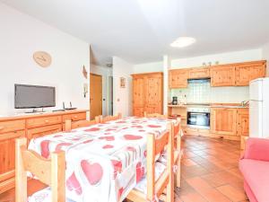 une salle à manger avec une table et une cuisine dans l'établissement Spacious Chalet with Garden near Ski Area in Tyrol, à Pozza di Fassa