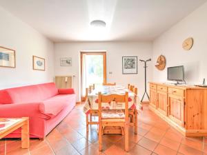a living room with a red couch and a table at Spacious Chalet with Garden near Ski Area in Tyrol in Pozza di Fassa