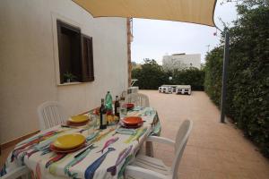 a table with chairs and a tablecloth on a patio at 9 Nereide in San Vito lo Capo