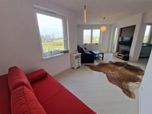 a living room with a red couch and a rug at APARTAMENT NA POLNEJ in Ustka