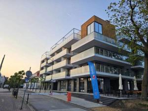 a building with a blue sign in front of it at Apartament z widokiem na port in Mrzeżyno