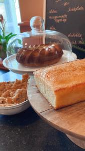 a table with two plates of bread and a chocolate doughnut at De Levensboom - Het Oud Gemeentehuis in Damme