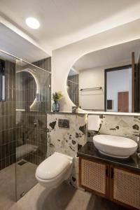 a bathroom with a toilet and a sink and a shower at 3BHK Villa With Private Pool & Concierge in Asagao in Assagao