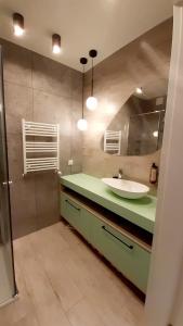 a bathroom with a sink and a mirror at Apartament z widokiem na port in Mrzeżyno