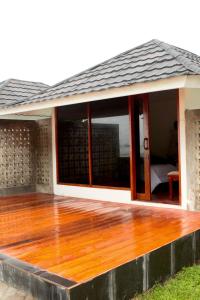 una terraza con puertas de cristal en una casa en SAESEA Private Beach & Resort, en Karanghawu