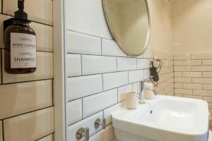 Baño blanco con lavabo y espejo en MOTIF 26 Pistoia, en Pistoia